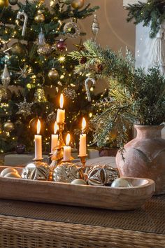 a tray with candles and ornaments in front of a christmas tree