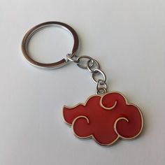 a red cloud shaped keychain on a white surface with a silver metal ring