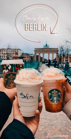 two people holding up starbucks drinks in front of the berlin skyline with text overlay