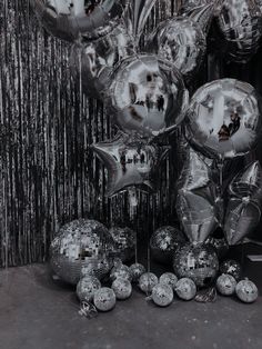 silver balloons and streamers in front of a curtain