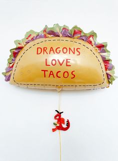 an inflatable balloon shaped like a taco with the words dragon's love tacos on it