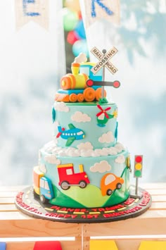 a multi layer cake with cars and trucks on it