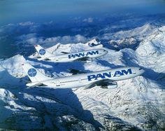 three air planes flying in the sky over snow covered mountains and valleys with blue writing on them