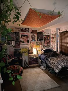 a bed room with a neatly made bed and posters on the wall next to it