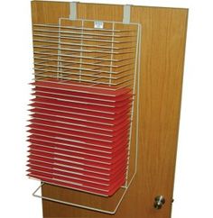 a stack of red folders sitting on top of a wooden shelf next to a door