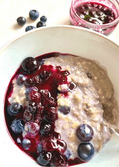 a bowl of oatmeal with berries and blueberries