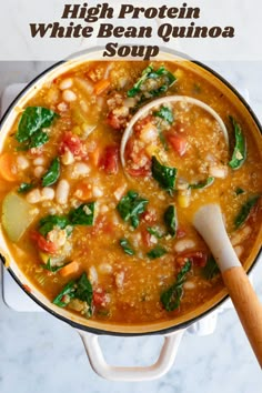 a pot full of soup with spinach, beans and carrots on the side