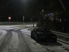 a car driving down a snowy road at night