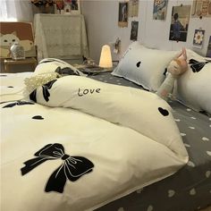 a bed with white sheets and black bows on the comforter is decorated with polka dots