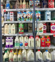 a refrigerator filled with lots of milk and dairy products on shelves next to each other