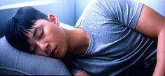 a young man sleeping on top of a pillow