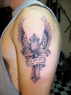 a man with a cross and wings tattoo on his arm