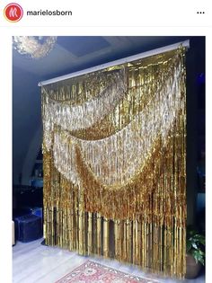 a gold curtain with fringes hanging from it's side in a living room