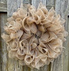 a burlock wreath hanging on a wooden fence