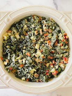 a white bowl filled with vegetables on top of a table