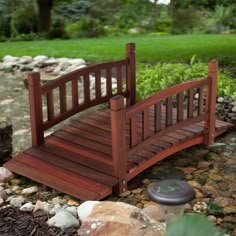 a small wooden bridge over rocks in a garden