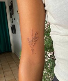 a woman's arm with a tattoo on it that has flowers in the middle