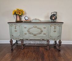 an old dresser is painted blue and has flowers in it on the top shelf, along with other antique furniture