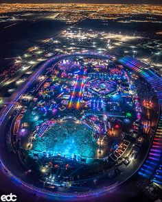 an aerial view of a city at night with lots of lights on the buildings and streets