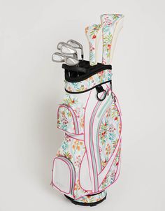 a golf bag that is decorated with flowers and butterflies on the front, has two clubs sticking out of it