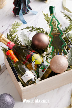 a wooden box filled with christmas decorations and wine bottles on top of a marble counter