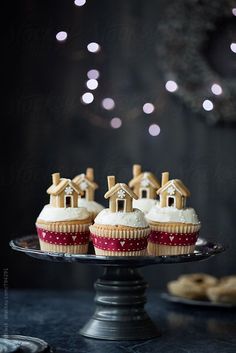 cupcakes with white frosting and gingerbread houses on top by luma studio for stockstation