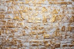 an old brick wall with gold paint on it