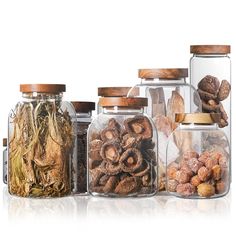 three glass jars filled with different types of nuts