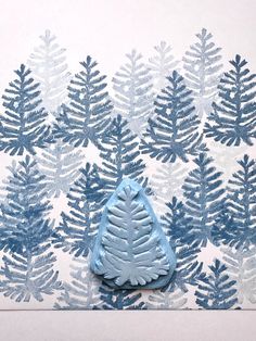 a blue and white wallpaper with pine tree designs on it, next to a small ceramic ornament