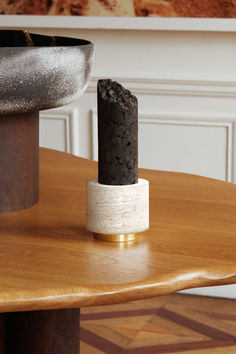 a wooden table topped with a black and white object on it's end stand