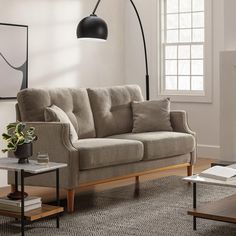 a living room with a couch, coffee table and lamp in the middle of it