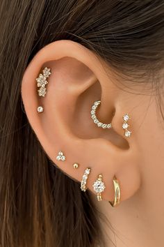 a woman's ear with three different types of piercings