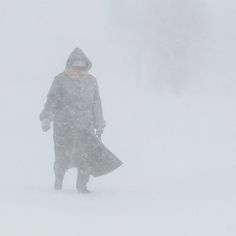 a person standing in the snow with a coat on