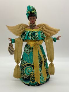 a figurine wearing a green and gold dress