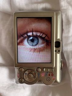 an old cell phone with the image of a blue eye on it's screen