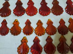 red glass ornaments are arranged in rows on a white tableclothed surface and placed next to each other