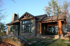 a stone and wood house in the woods