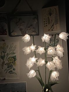 a vase filled with white flowers sitting on top of a table next to framed pictures