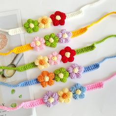 crocheted flower headbands are laid out on a white table with scissors