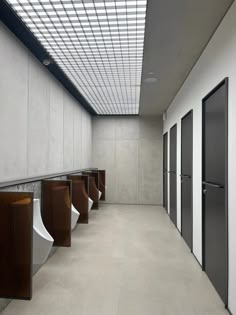 a row of urinals sitting next to each other in a room filled with white walls