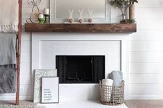 the fireplace is painted white and has been decorated with flowers, blankets, and other items