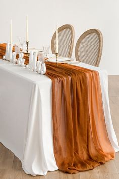 an orange and white table cloth on a dining room table