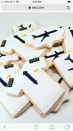 cookies decorated like shirts and planes are on display for the guests to eat at this event