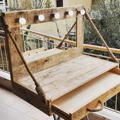 a wooden bench with lights on it sitting in front of a window