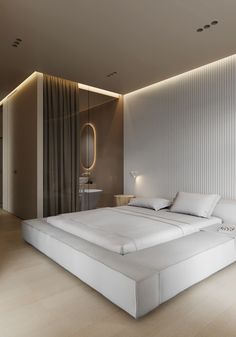 a large white bed sitting in a bedroom next to a tall mirror on the wall