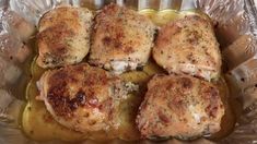 some chicken is sitting on top of potatoes in a glass dish with sauce and seasoning