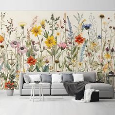 a living room with flowers painted on the wall and a couch in front of it