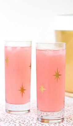 two glasses filled with pink liquid on top of a table