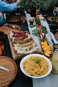 a table topped with plates and bowls filled with different types of food next to drinks