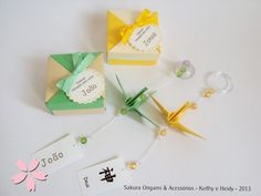 three origami pieces with tags attached to them on a white surface next to each other